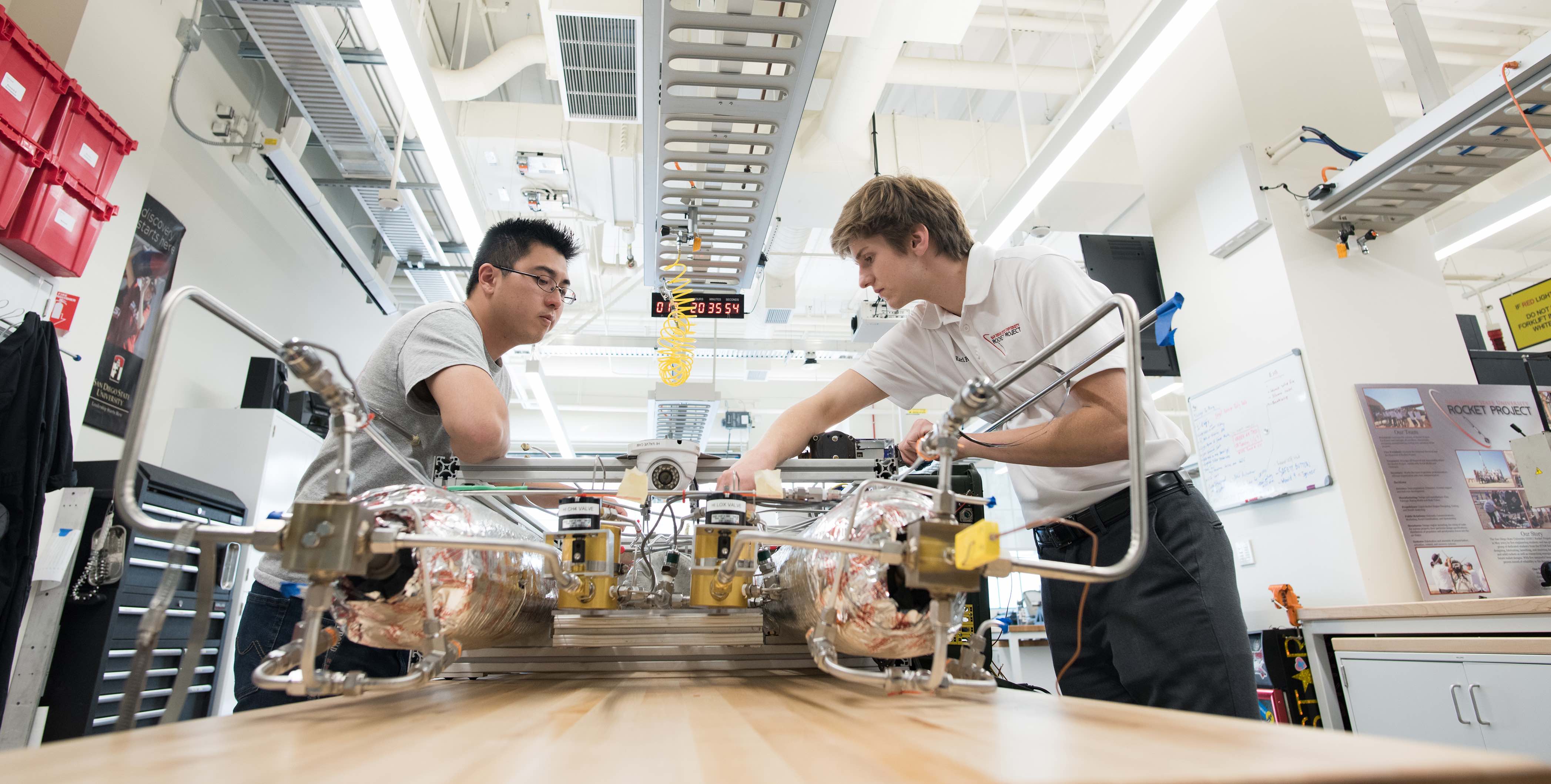 Engineering students working on a rocket engine.