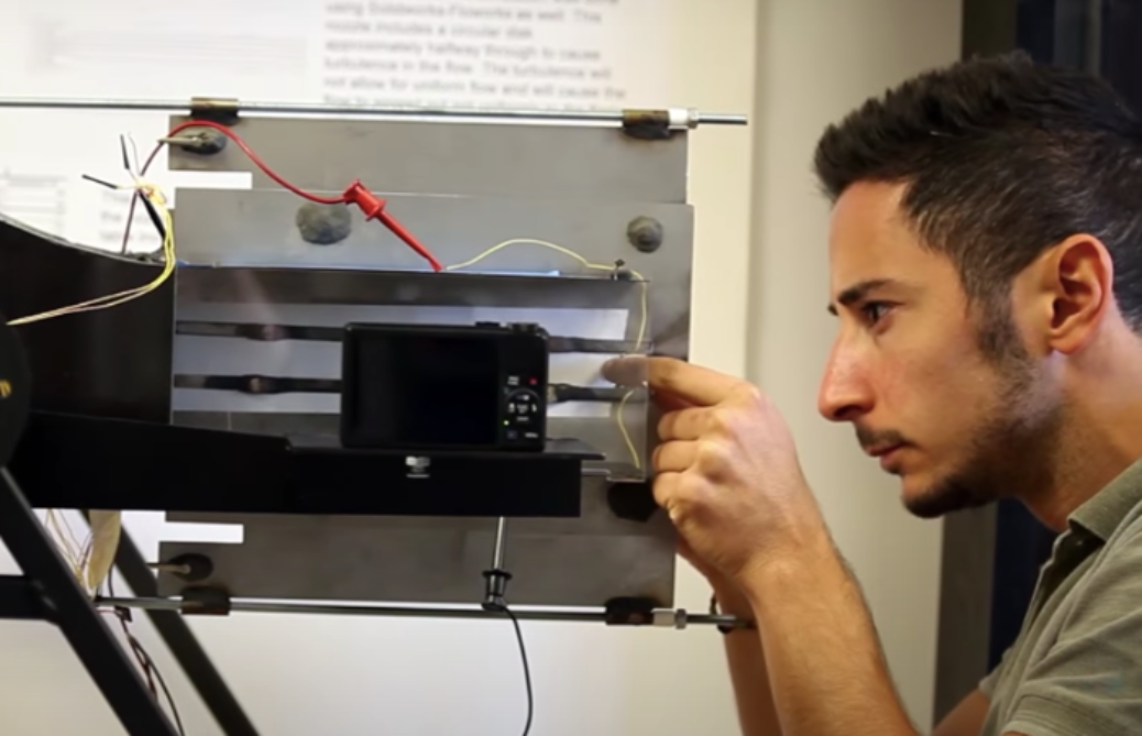 A mechancial engineering student sets up an instrument that tests the properties of fire in space