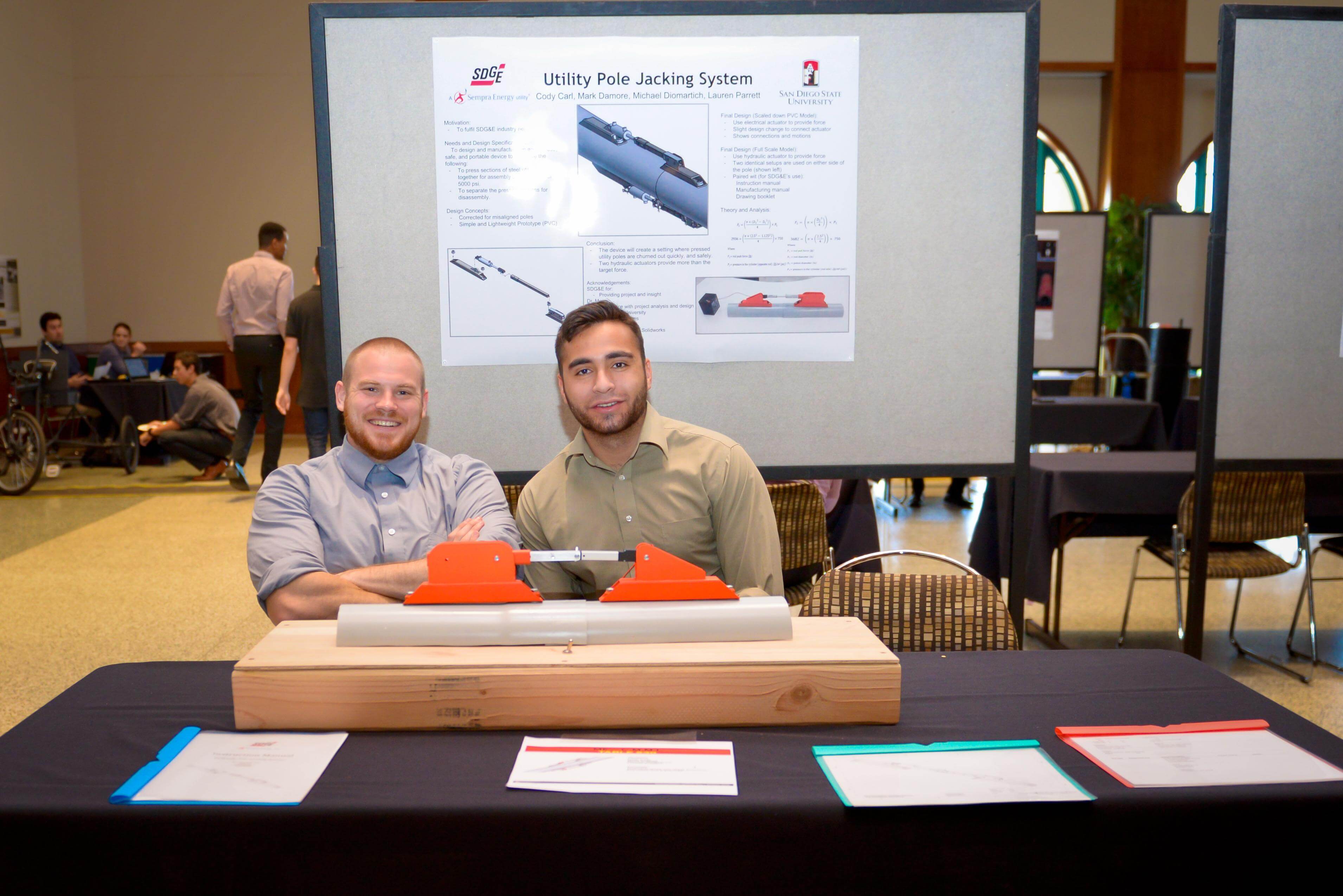 Two students sit with their project.