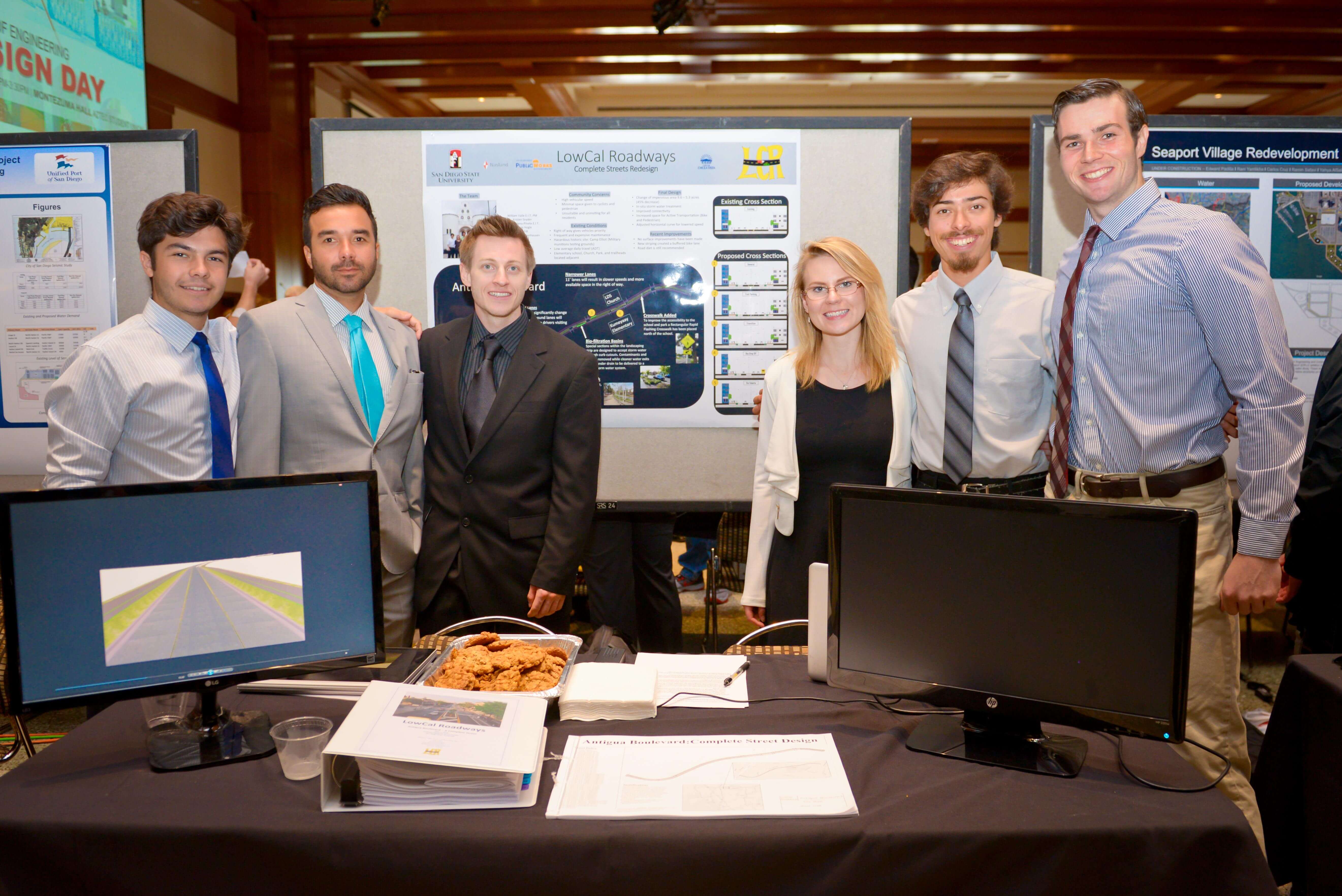 Group of six standing behind project.