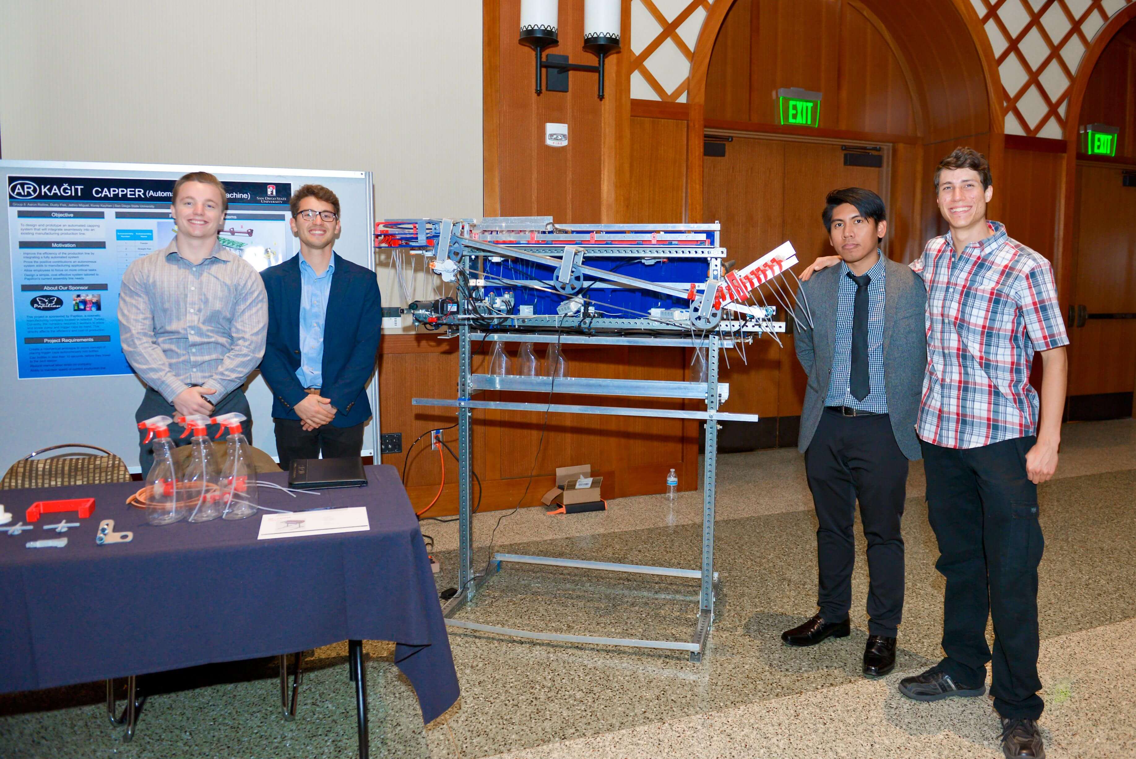 Team members and their prototype for an automated capping system.