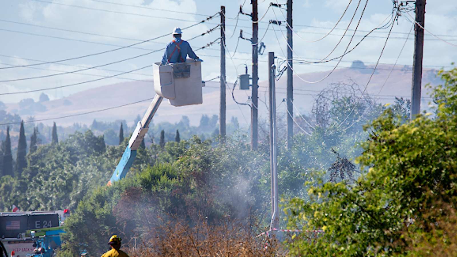 Electrical worker repairs power lines that caused a fire. (Adobe Stock)