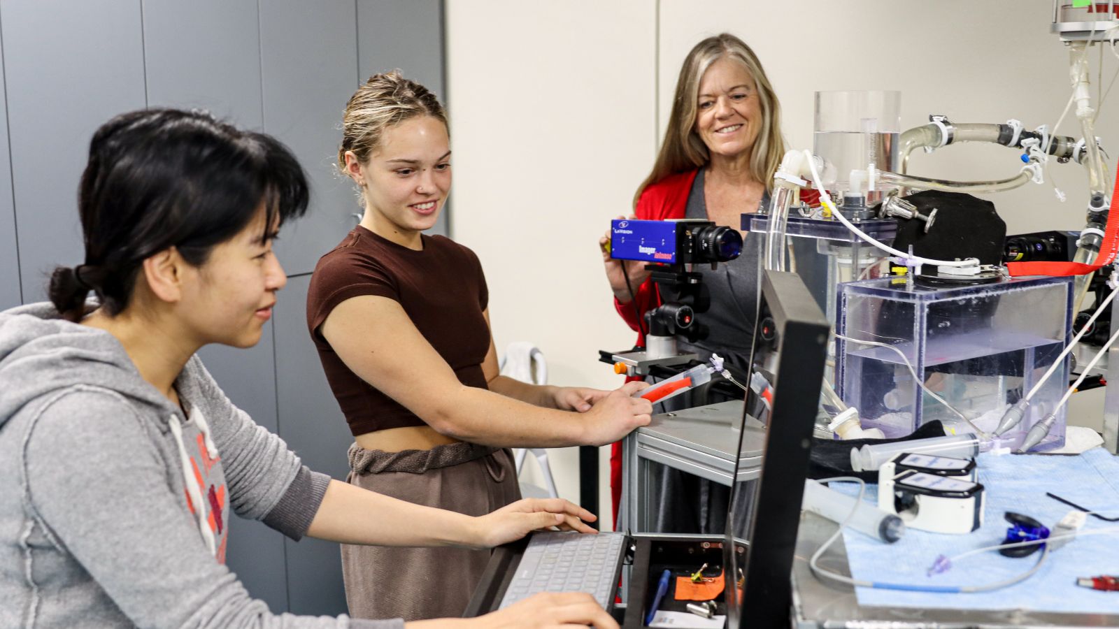 Karen May-Newman (right) oversees student researchers Britton Mennie (middle) and now-PhD graduate Vi Vu (left) as they work on three-dimensional flow visualization. (SDSU/Melinda Sevilla)  
